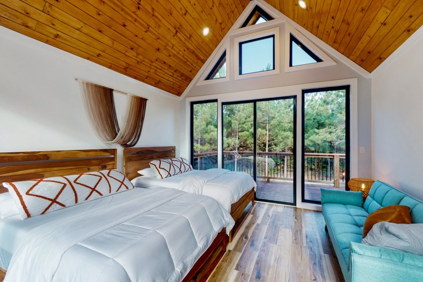 Wood-lined bedroom overlooking the trees — Blue Spruce · Broken Bow